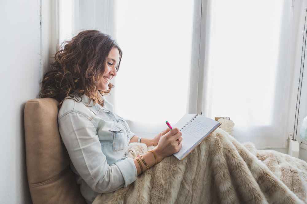 Mujer escribiendo un diario emocional para comprender sus emociones y conocerse mejor.